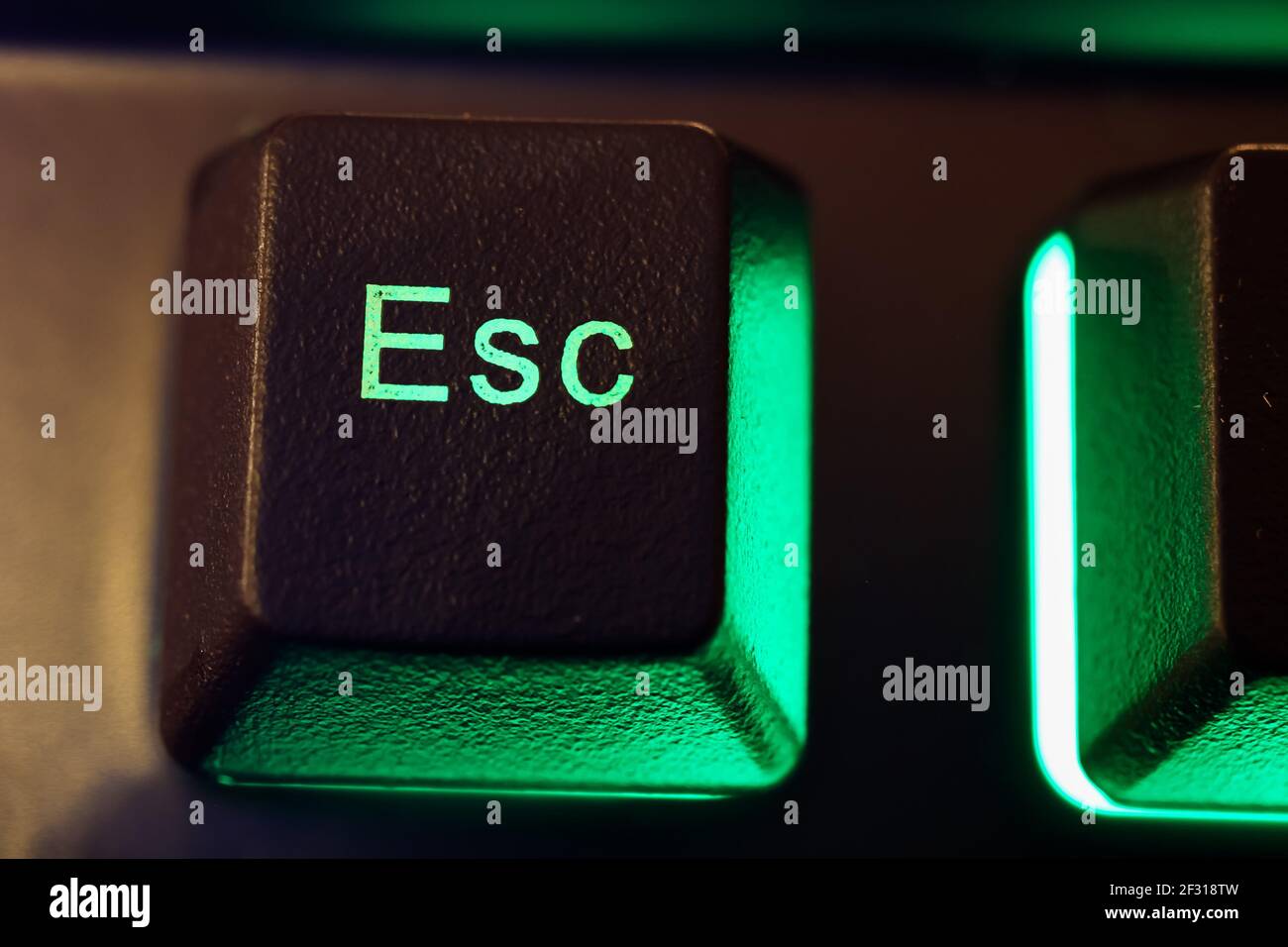 Makro Nahaufnahme der isolierten grün beleuchteten esc-Taste am Computer Tastatur (Fokus auf Buchstabe S) Stockfoto