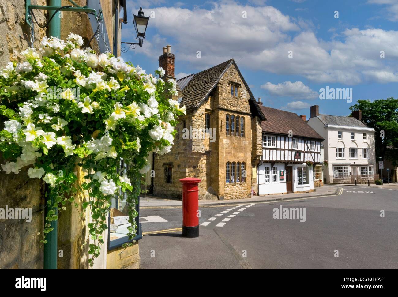 Sherborne historischen Stadtzentrum High Street mit hängenden Körbe Petunien Blumen und typische rote Briefkasten Dorset England UK Stockfoto