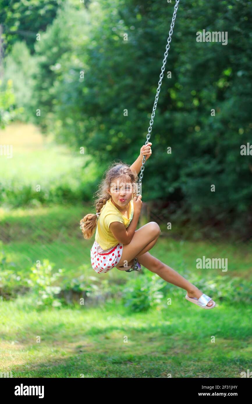 Portrait von schönen kleinen Mädchen schwingt und spielt im Sommer Park. Weich fokussiert Stockfoto