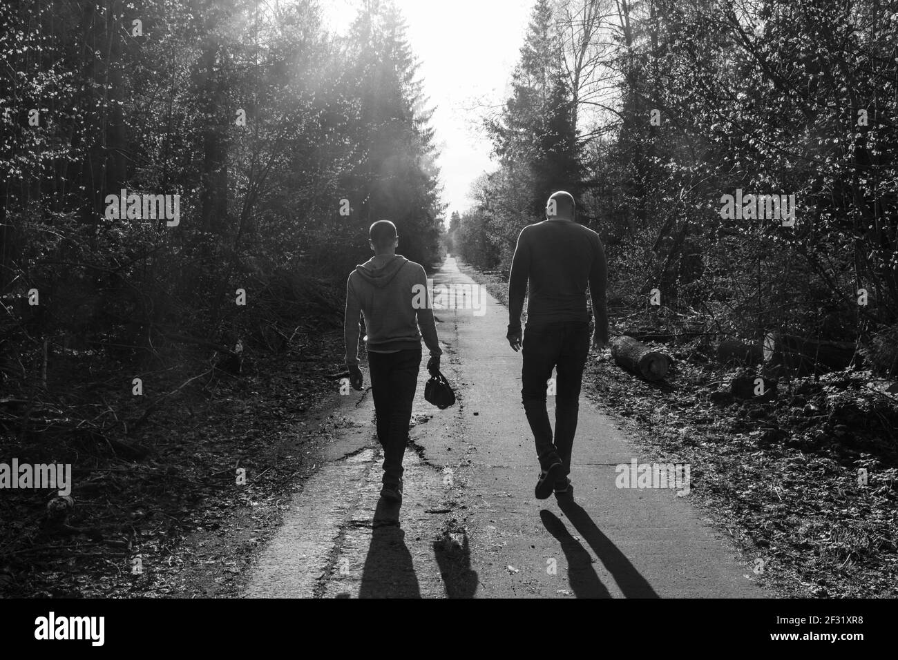 Zwei Freunde laufen entlang der Gasse, traurige Stimmung, Atmosphäre des Streits oder Groll; Schwarz-Weiß-Foto Stockfoto
