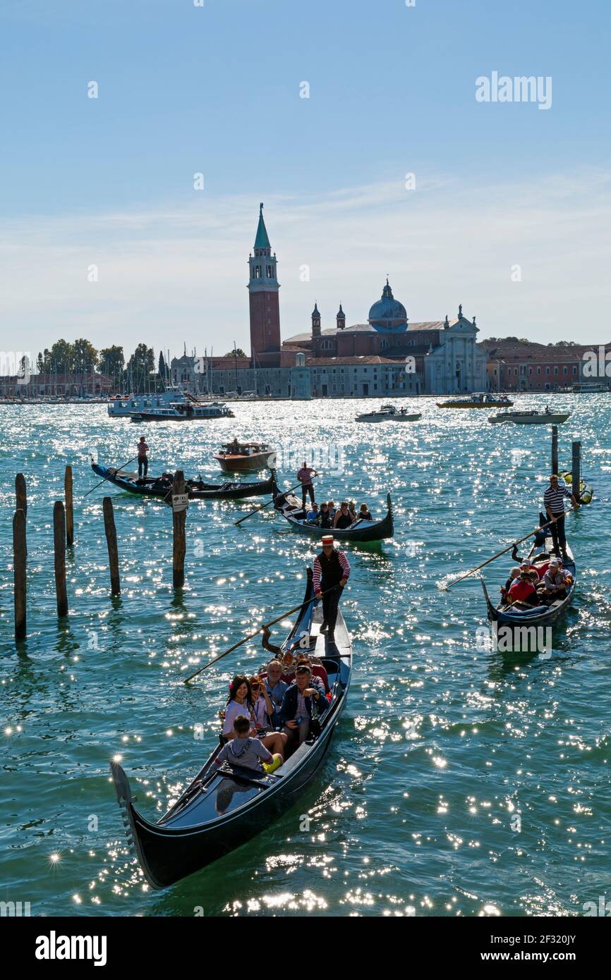 Italien, Venedig, Gondoliere, die mit Gondeln auf dem Markukanal fahren San Giorgio Maggiore im Hintergrund Stockfoto
