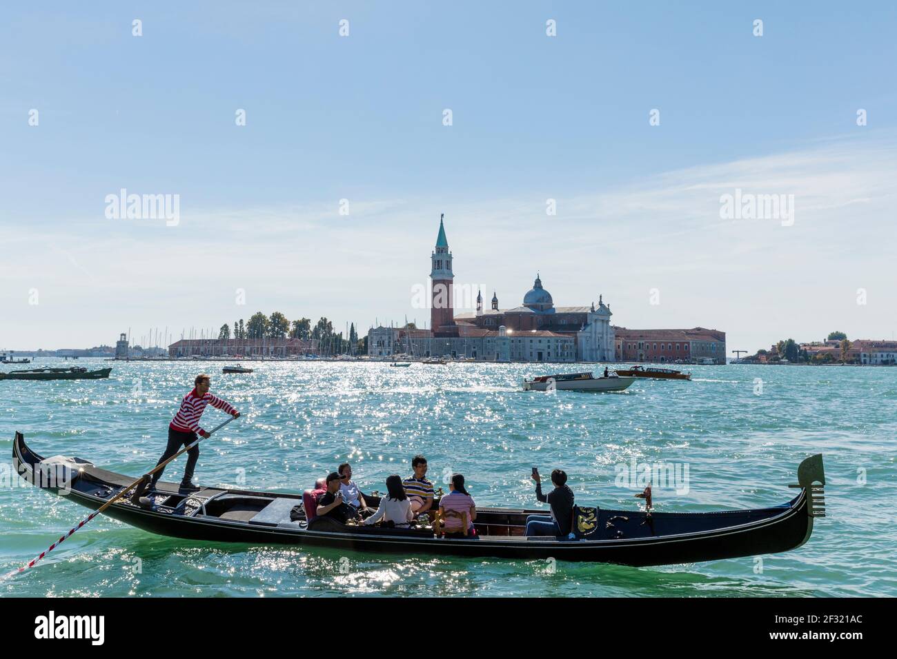 Italien, Venedig, Gondoliere, die mit Gondeln auf dem Markukanal fahren San Giorgio Maggiore im Hintergrund Stockfoto