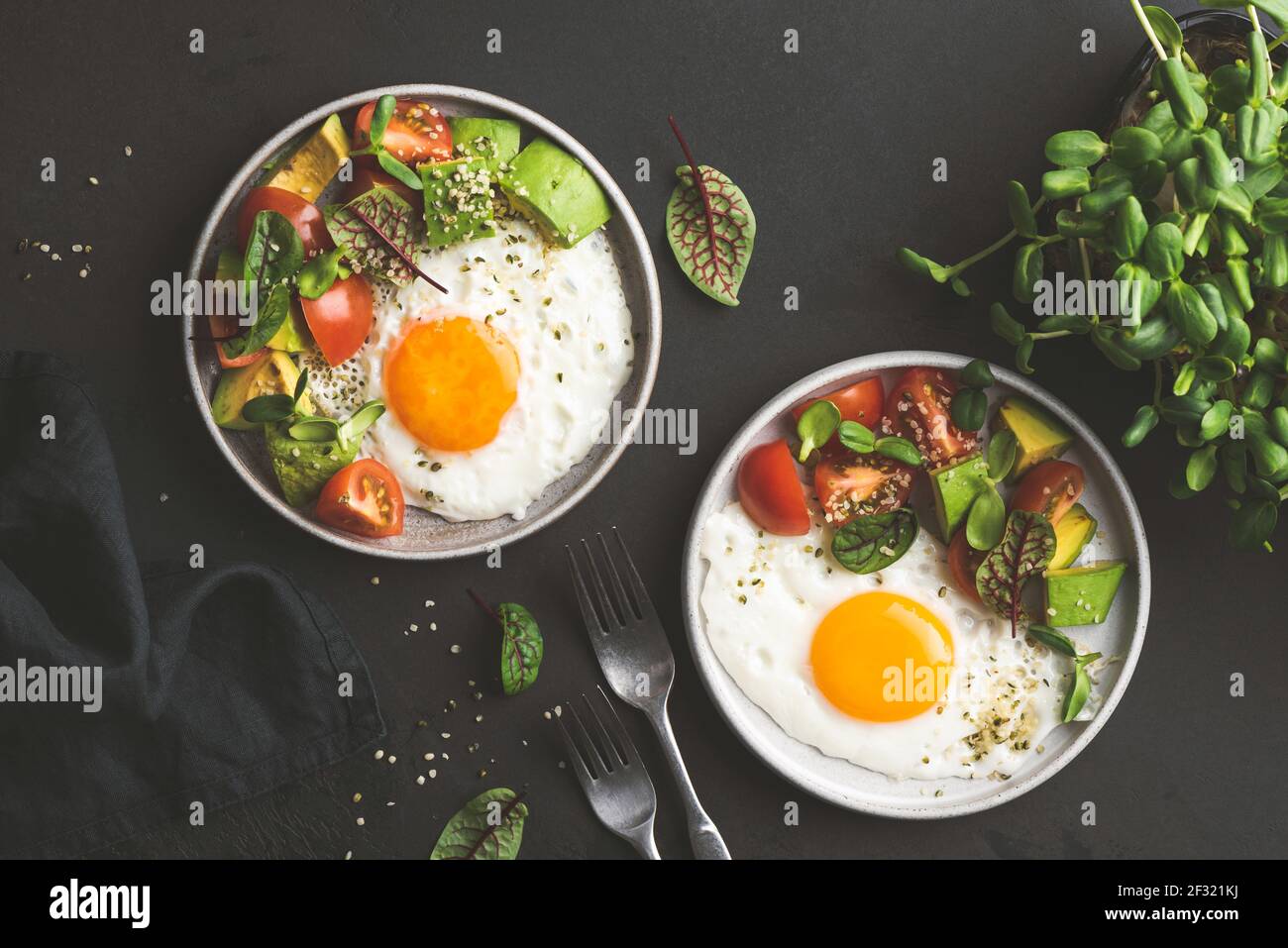 Sonniger Eierfrühstück mit Avocado-Salat auf dem Teller, Blick von oben. Gesundes Frühstück Stockfoto
