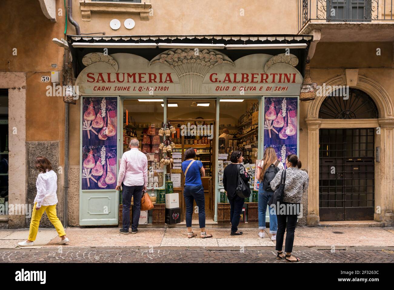 Italien, Verona, Salumeria mit Menschen vor. Eine Salumeria ist ein Lebensmittelproduzent und Einzelhandelsgeschäft, das Salumi und andere Lebensmittel produziert. Stockfoto