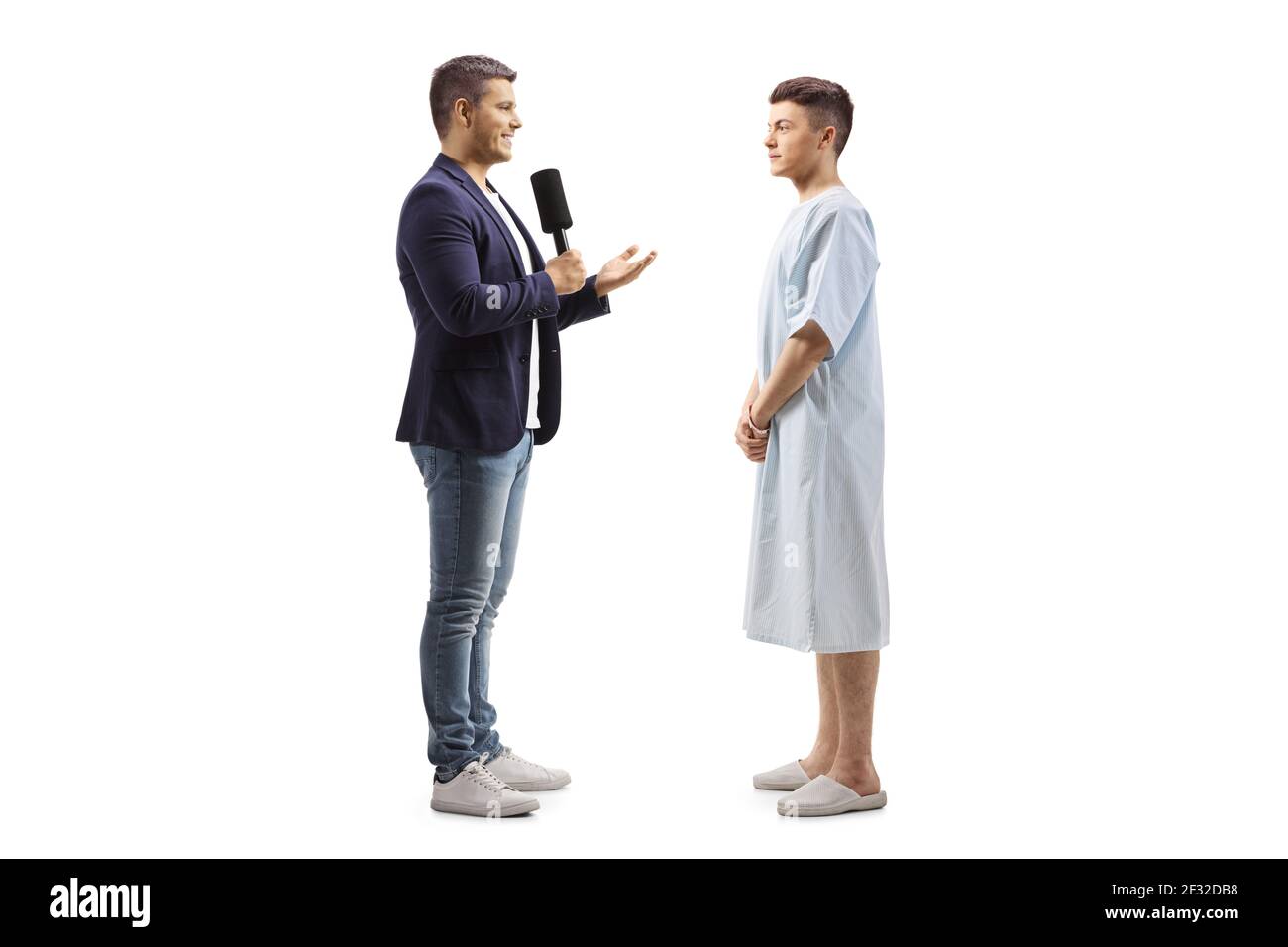 Reporter interviewt einen jungen männlichen Patienten in einem Krankenhauskleid Isoliert auf weißem Hintergrund Stockfoto