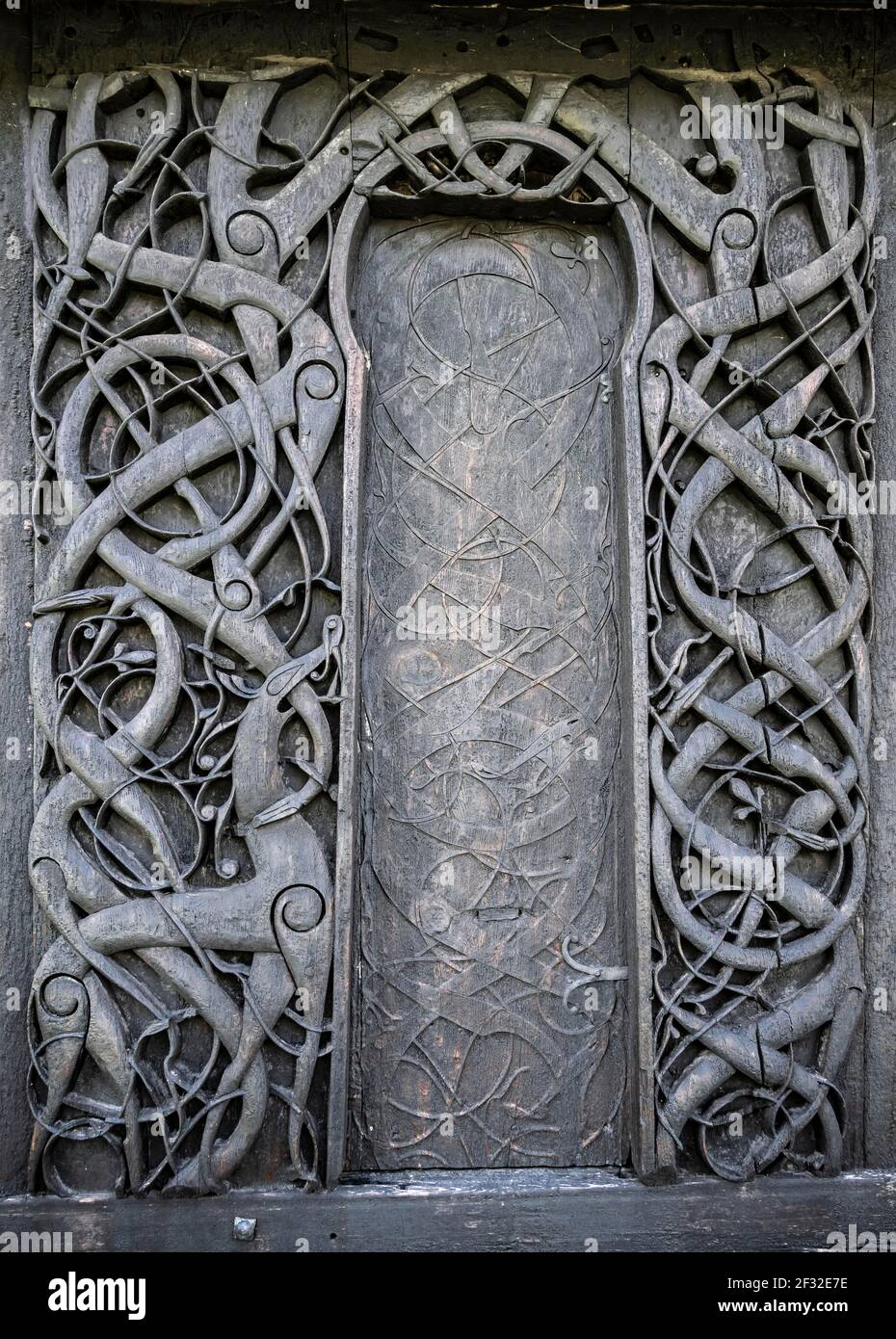 Kunstvoll geschnitzte Nordportal, keltische Kunst mit Traditionen der Wikinger, Urnes Stabkirche, romanische Kirche aus ca. 1130, Vestland, Norwegen Stockfoto