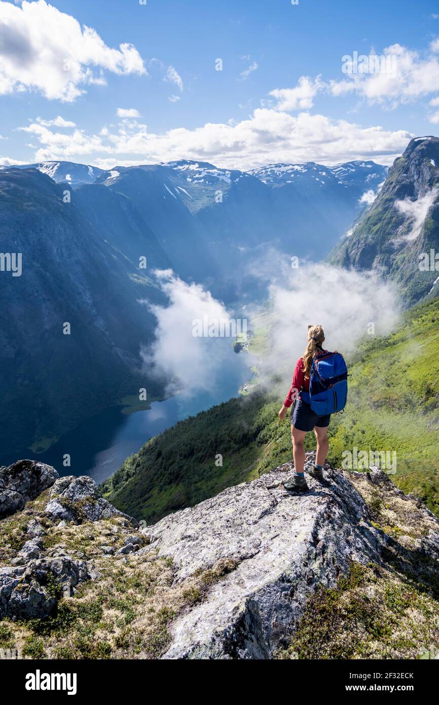 Wanderer mit Blick ins Tal, Blick von der Spitze des Breiskrednosi, Berge und Fjord, Naeroyfjord, Aurland, Norwegen Stockfoto