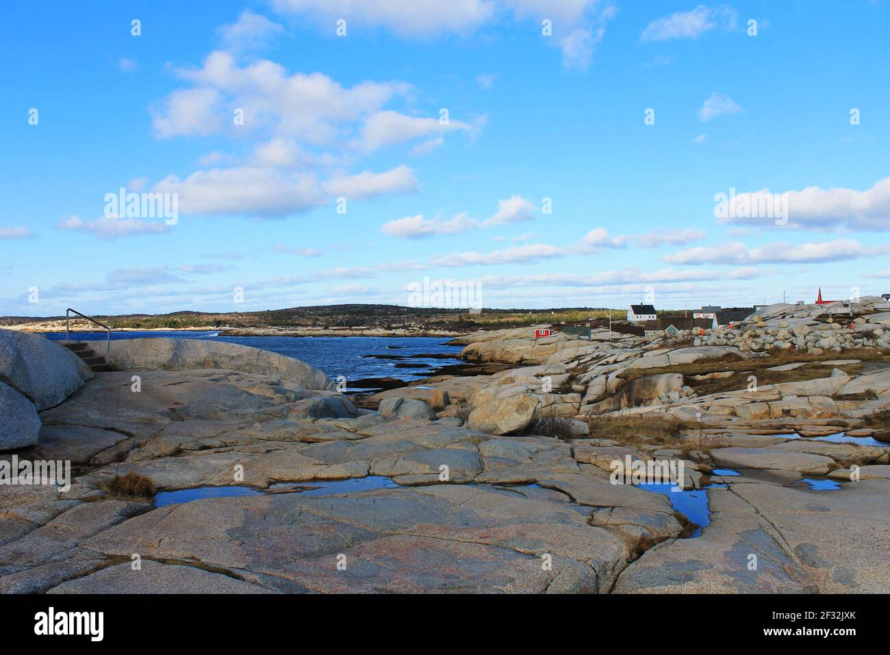 Graue Felsen, die von den Wellen glatt getragen werden, entlang der zerklüfteten Küste von Nova Scotia in Peggy's Cove. Stockfoto