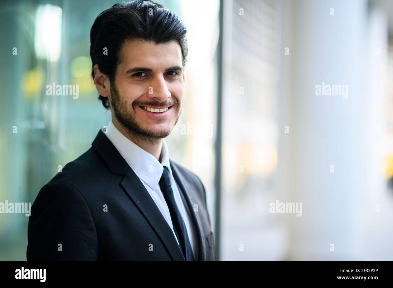 Junger Geschäftsmann im Freien lächelt selbstbewusst Stockfoto