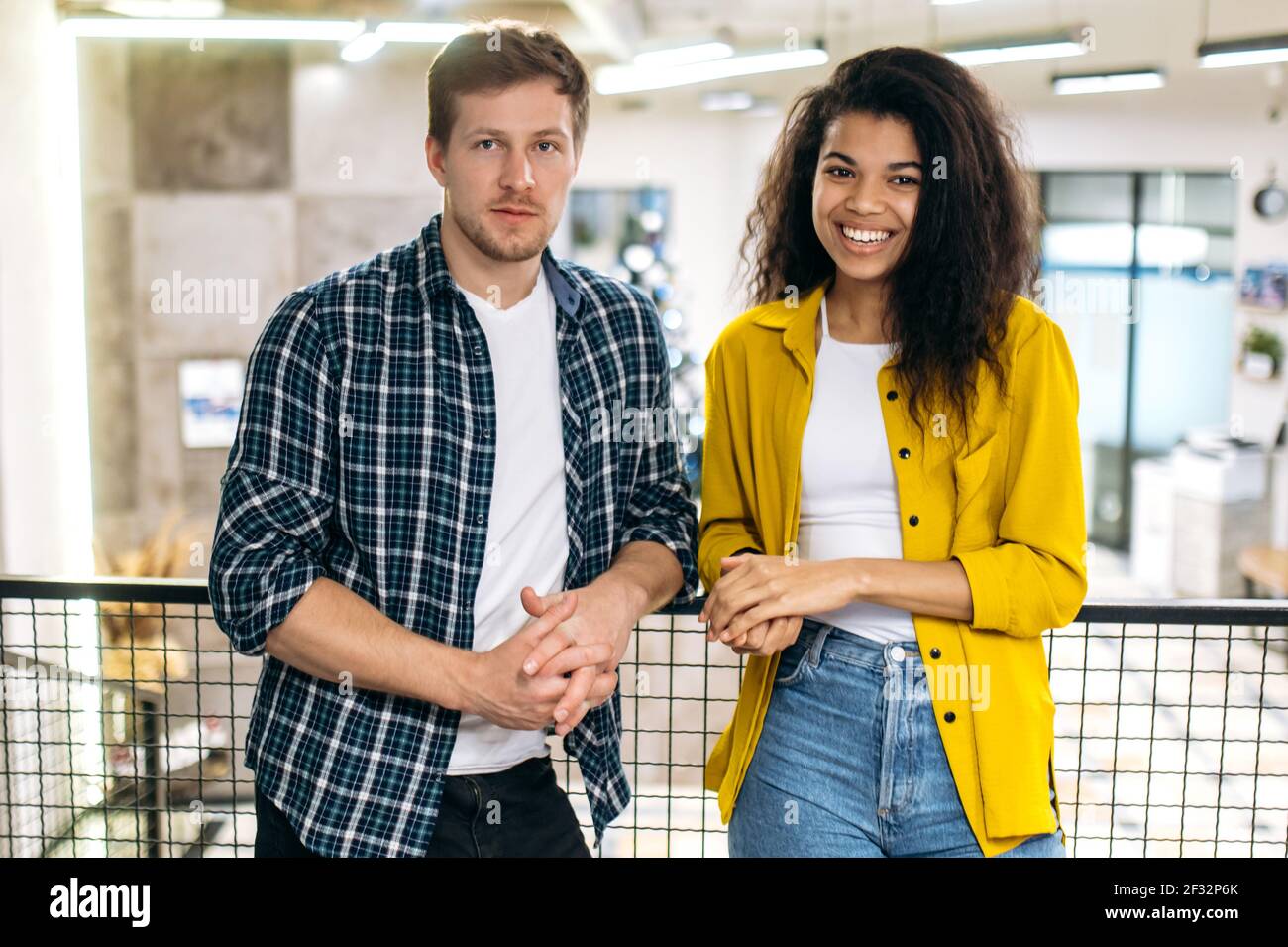 Portrait von multiethnischen Freunden Studenten oder Kollegen in stilvoller Kleidung am Arbeitsplatz. Glücklicher junger Erwachsener erfolgreicher männlicher und weiblicher Angestellter, der die Kamera anschaut, lächelt, arbeitet oder studiert zusammen Stockfoto