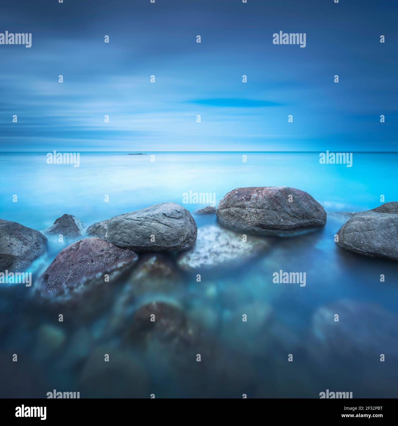 Felsen, weiches Meer und Wolken am Himmel, schöne Landschaft in Langzeitbelichtung Fotografie. Castiglioncello, Toskana, Italien. Stockfoto