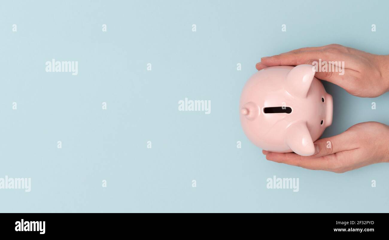 Mann, der ein Sparschwein hält. Budget, Geld sparen Konzept Stockfoto