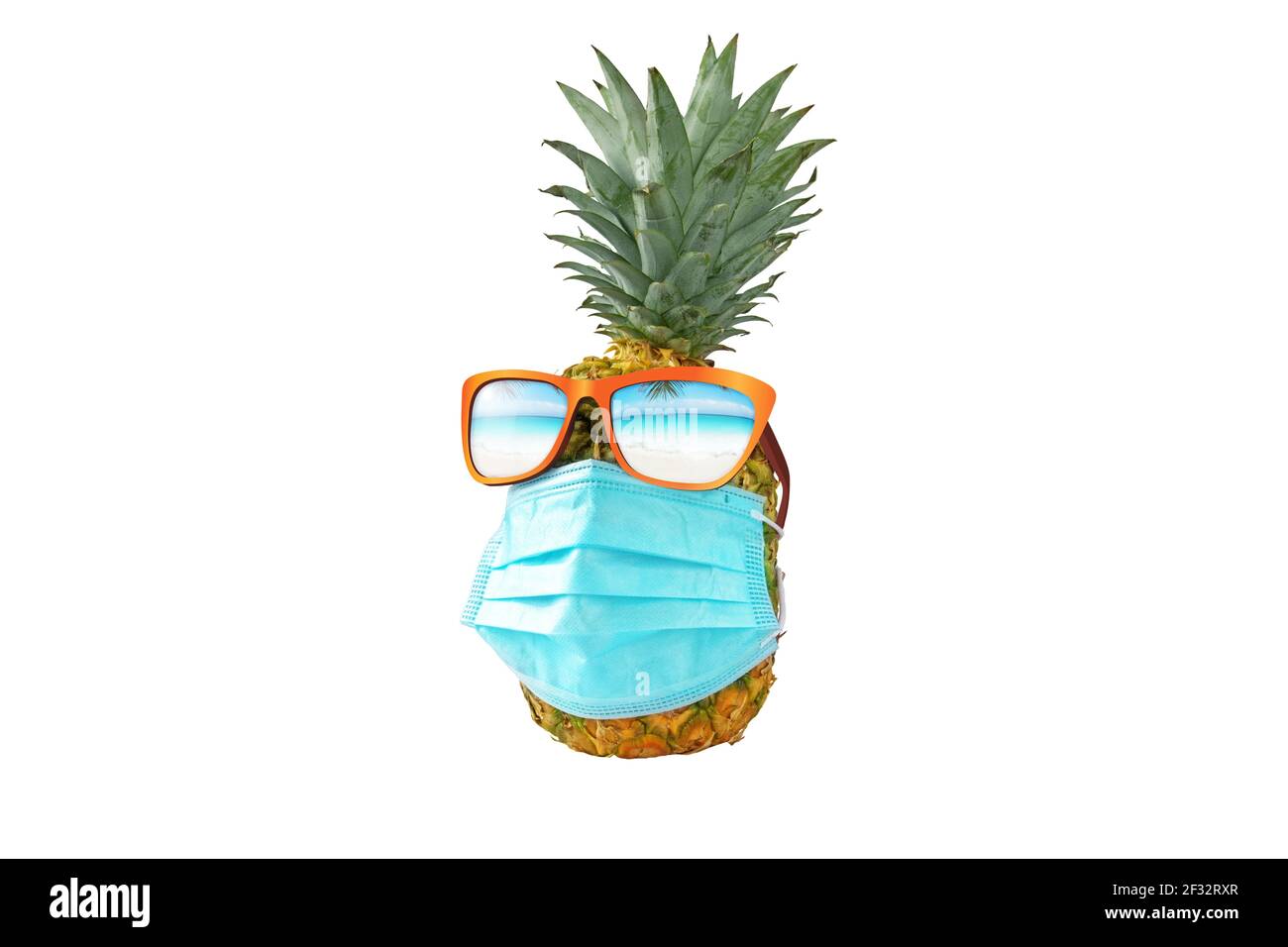 Ananas trägt blaue OP-Schutzmaske und Sonnenbrille mit reflektierten tortypischen Strand. Sommerurlaub Sicherheitsreise während Coronavirus Pandemie Stockfoto