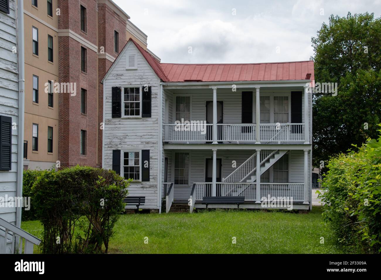 Ein kleines weißes Haus im Charlestonischen Stil mit einem Backsteinrot Dach und Veranda Stockfoto