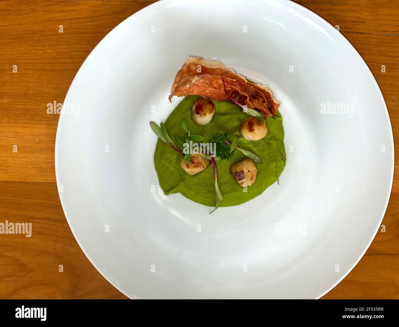 Gourmet-Essen. Jakobsmuscheln mit Erbsencreme. Meeresfrüchte. Stockfoto