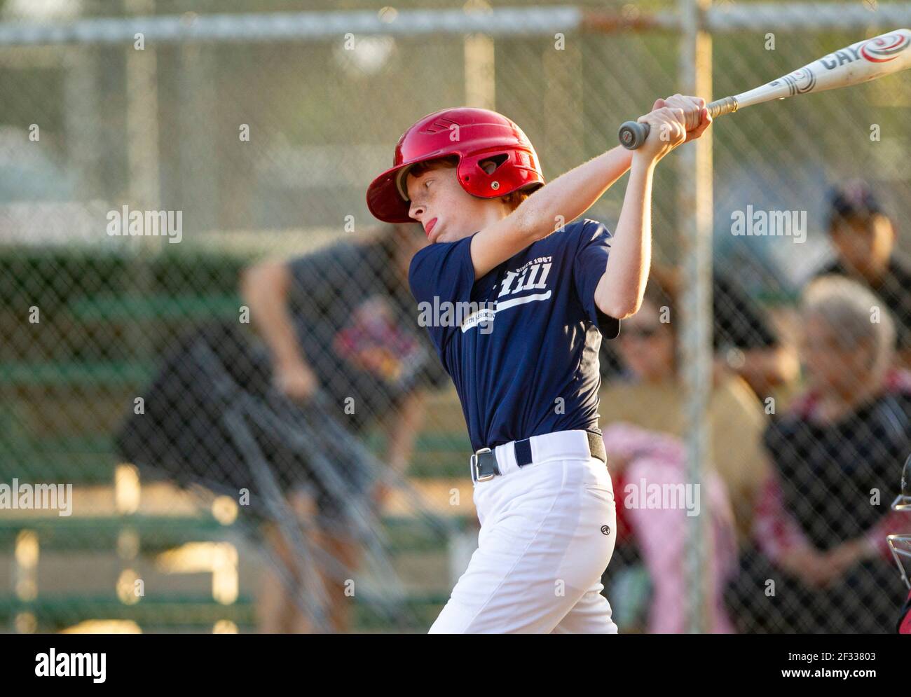 Ein rotköpfiger Teenager, der während eines Baseballspiels zuschlagend war. Stockfoto