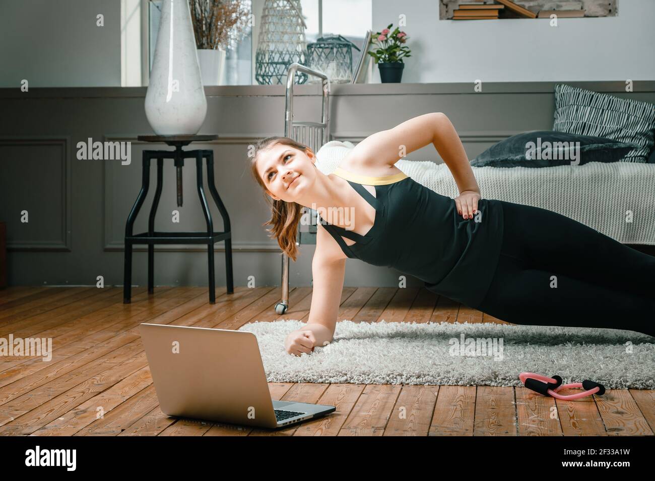 Die junge Frau geht zu Hause zum Sport. Sportler mit