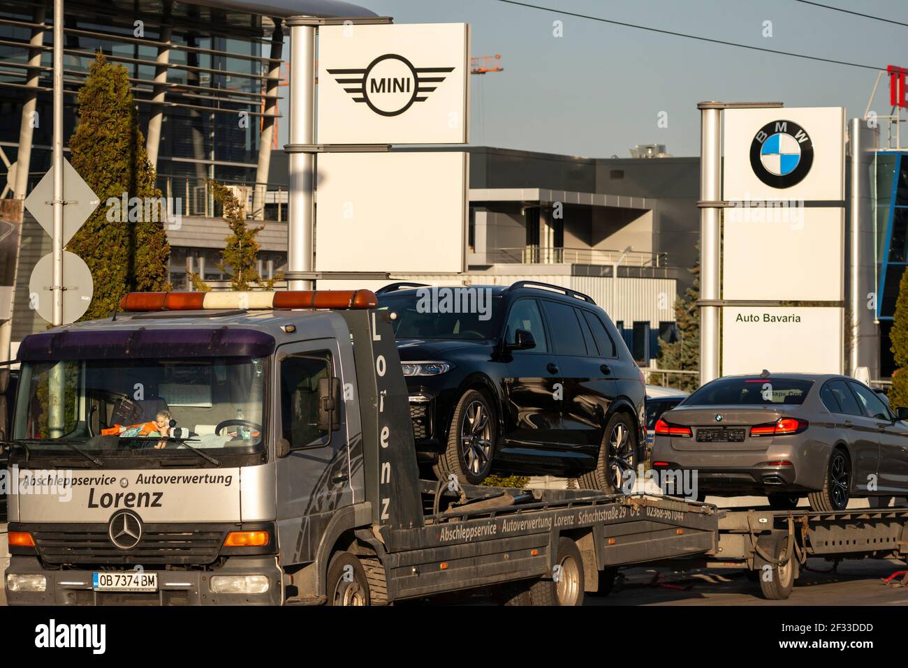 BMW-Fahrzeuge werden auf Mercedes-Anhänger-Lkw am Auto Bavaria Autohändler und Händlerstandort in Sofia, Bulgarien, Europa, EU verladen Stockfoto