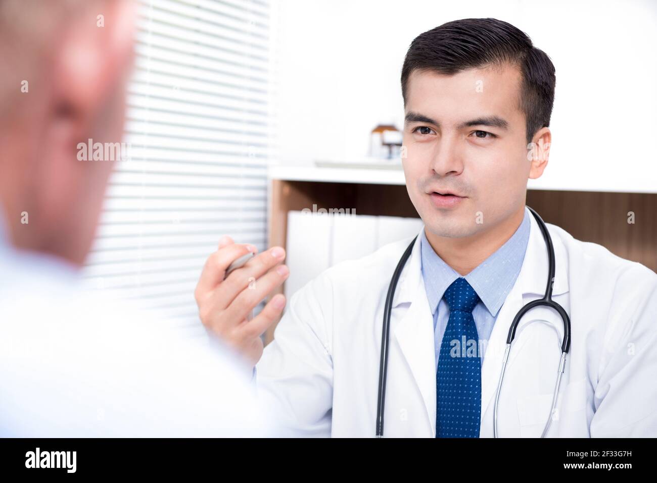 Arzt im Gespräch mit älteren männlichen Patienten - medizinische Beratung und Untersuchungskonzepte Stockfoto