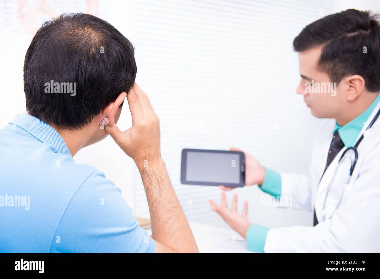 Mann mittleren Alters Beratung Arzt über Haarausfall Problem Stockfoto