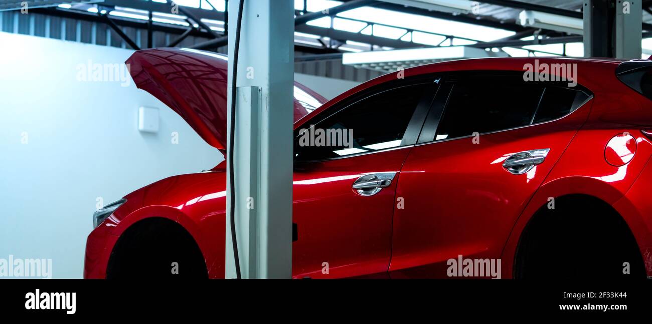Autowerkstatt. Red SUV Auto ist Aufzug in der Garage für Reparatur-und Wartungsservice. Auto-Service mit angehobenen Fahrzeug. Karosserie in Werkstatt für angehoben Stockfoto