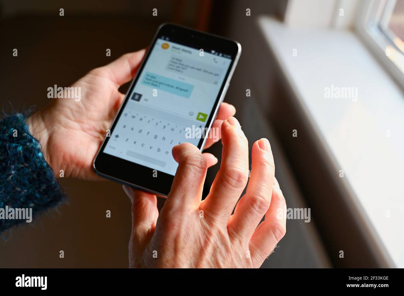 Nahaufnahme einer älteren Frau, die mit ihrem Mobiltelefon SMS schreibt. Stockfoto