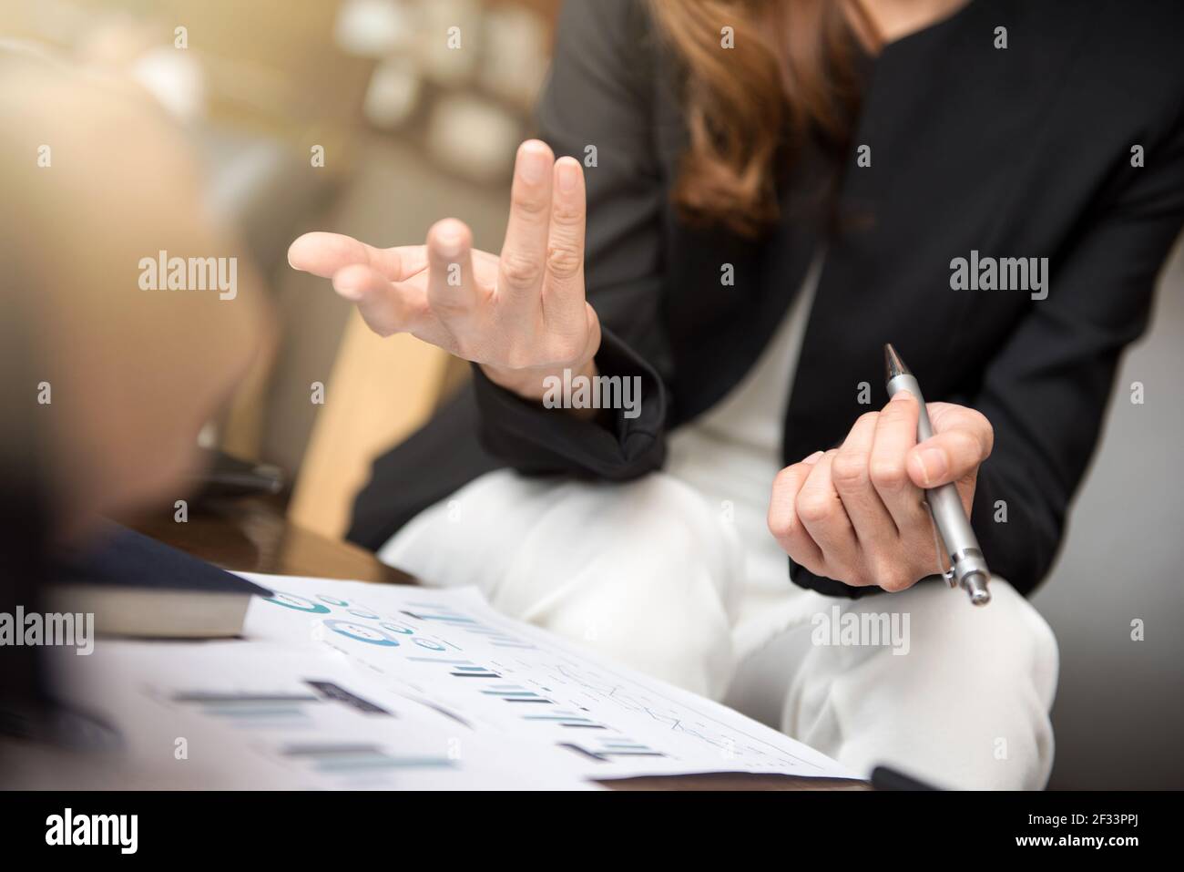 Geschäftsfrau mit Handgesten beim Sitzen und Sprechen im Besprechung Stockfoto