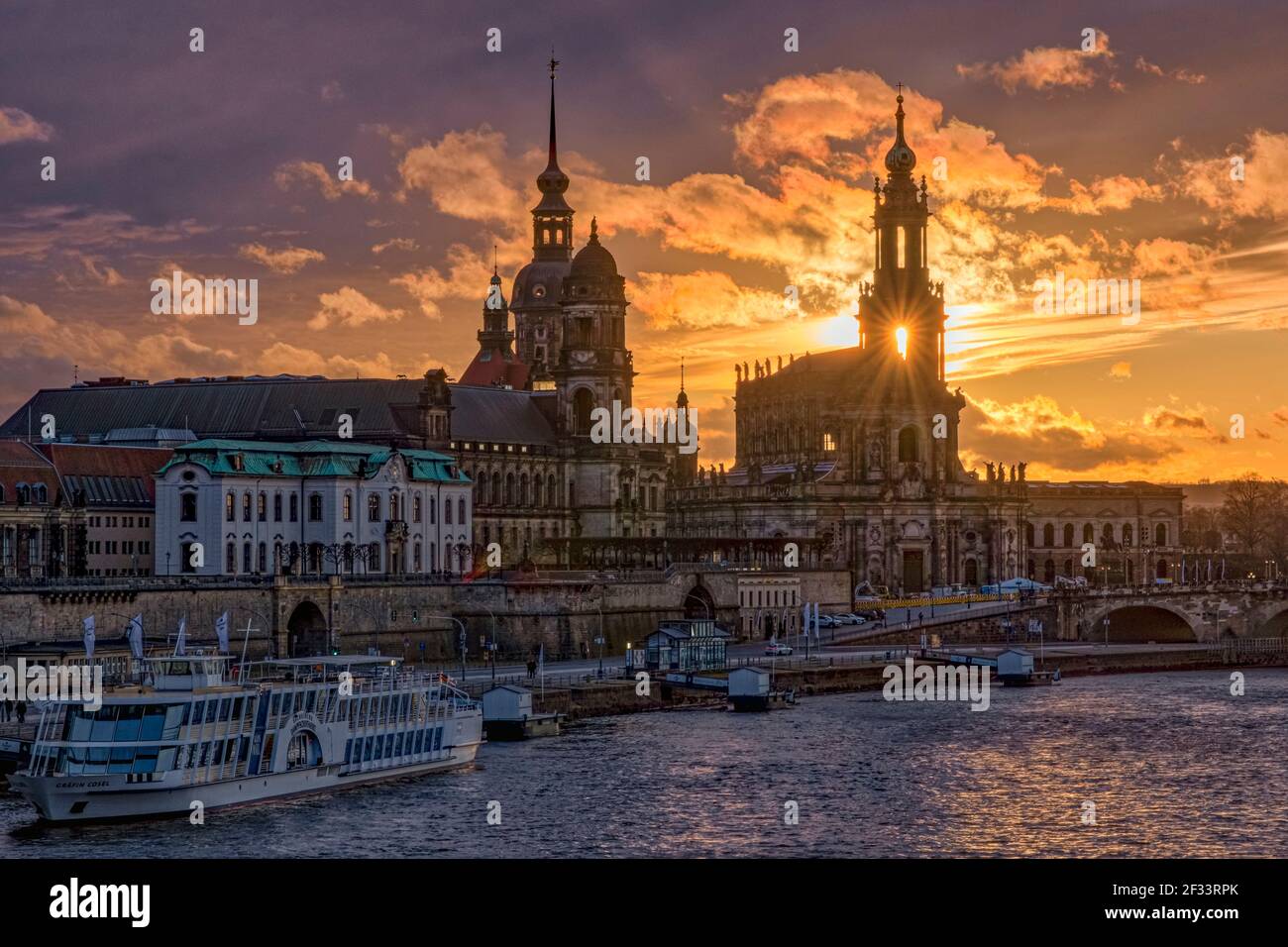 Die Sonne untergeht hinter dem Dreifaltigkeitsdom in der Altstadt, über die Elbe gesehen. Stockfoto