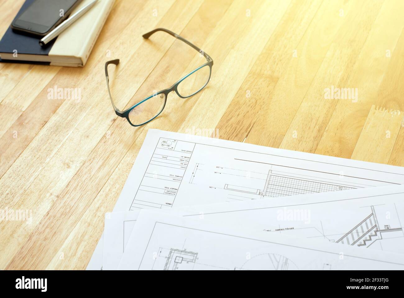 Architekturentwürfe, Brillen, Buch und einige Ausrüstungen auf Holztisch Stockfoto