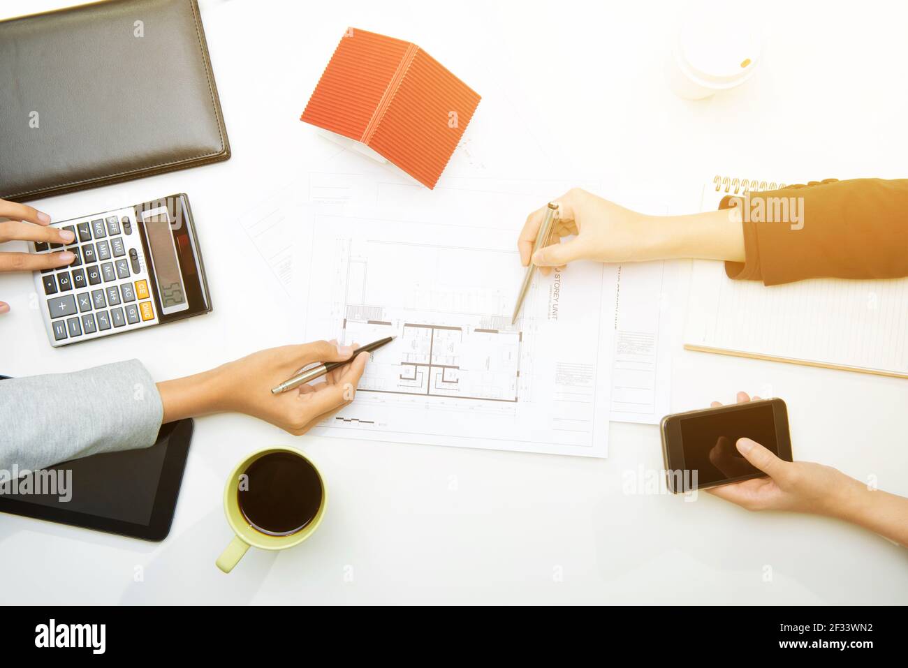 Geschäftsleute Hände halten Stifte und zeigen auf Blaupause in der Sitzung, Draufsicht - Immobilien-Investitionen und Finanzkonzept Stockfoto