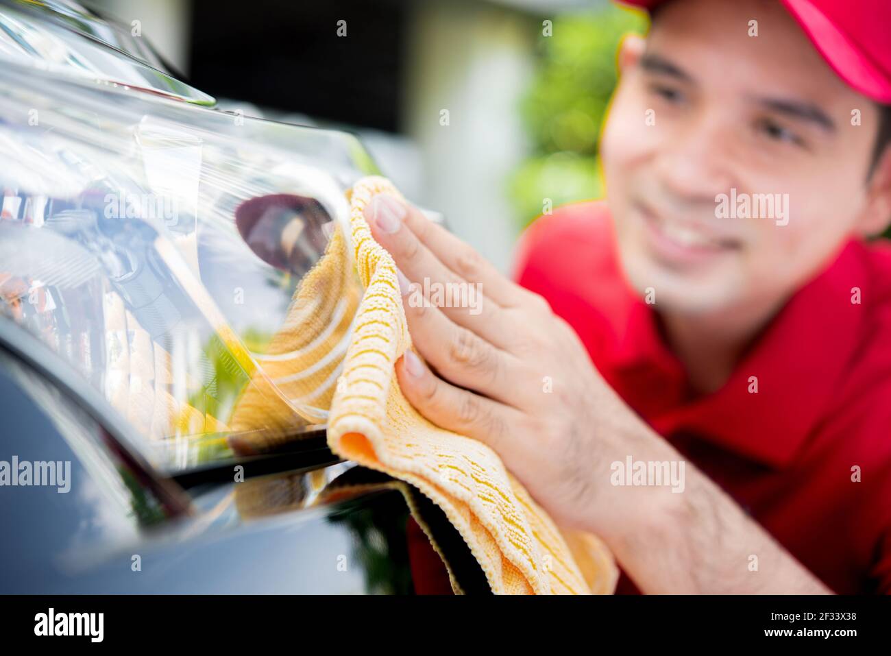 Ein Mann Reinigung Auto Scheinwerfer - Auto Detaillierung und Valeting Konzept Stockfoto