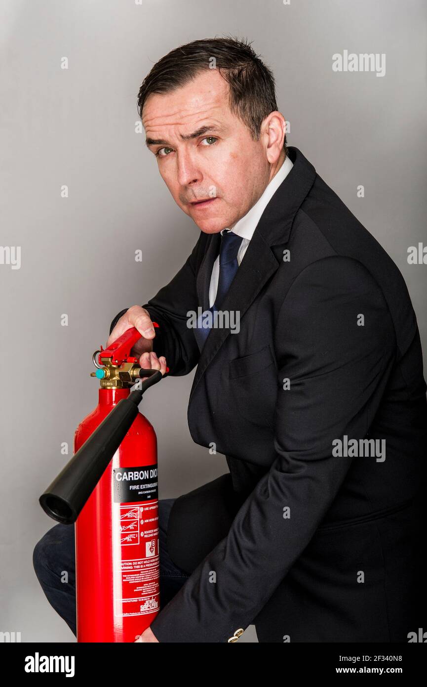 Mann in Smart Office Anzug halten Feuerlöscher,.Training in der Verwendung von Feuerlöschern. Stockfoto