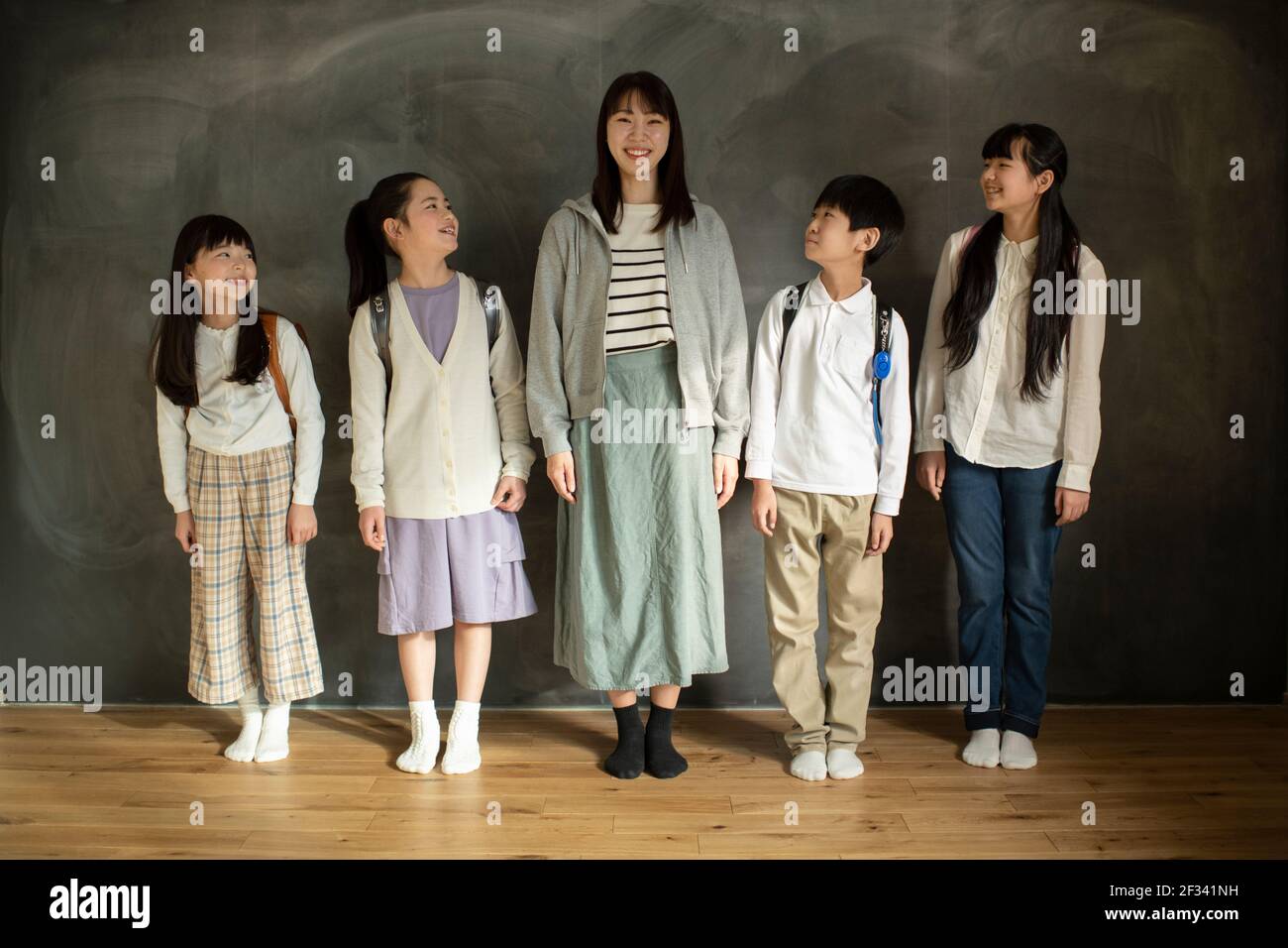 Grundschüler und Lehrer stehen in der Reihe Stockfoto