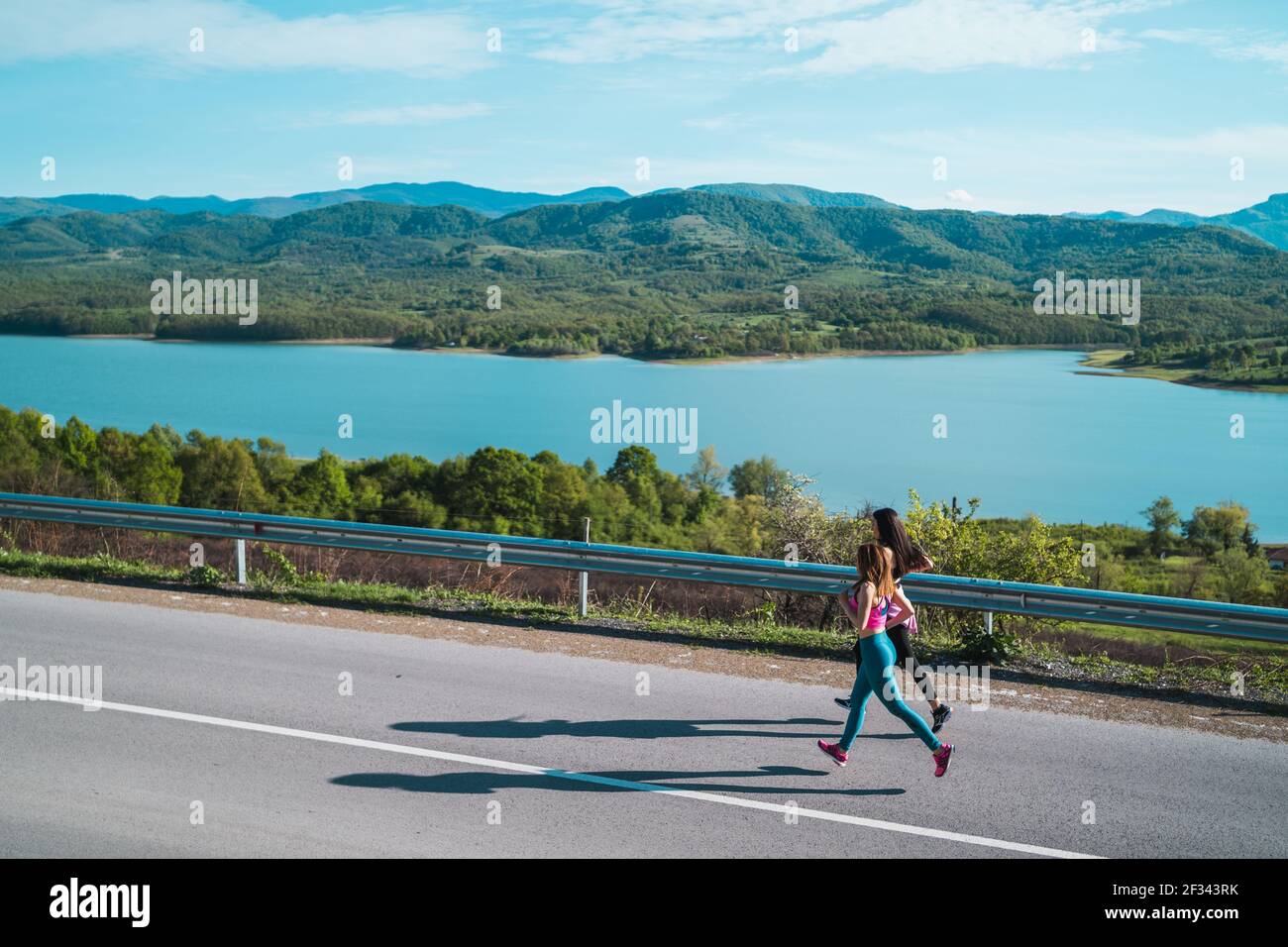 Fit weibliche Athleten laufen Joggen auf Asphaltstraße in der Nähe von See Stockfoto