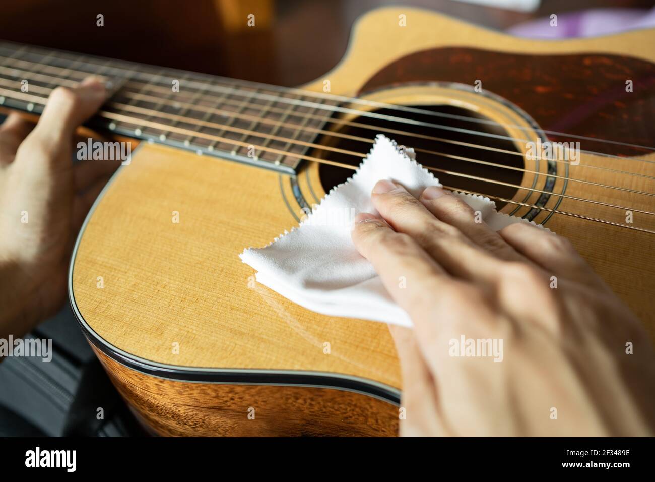 Reinigung Akustikgitarre mit Mikrofasertuch Stockfoto