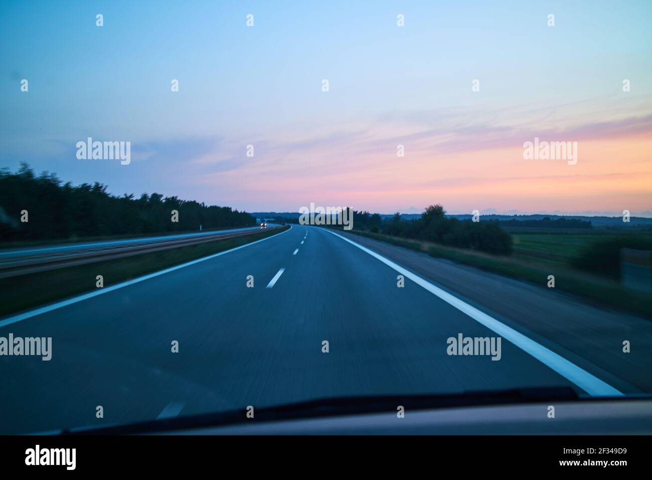 Autofahrt auf dem Land mit violettem Sonnenuntergang Stockfoto