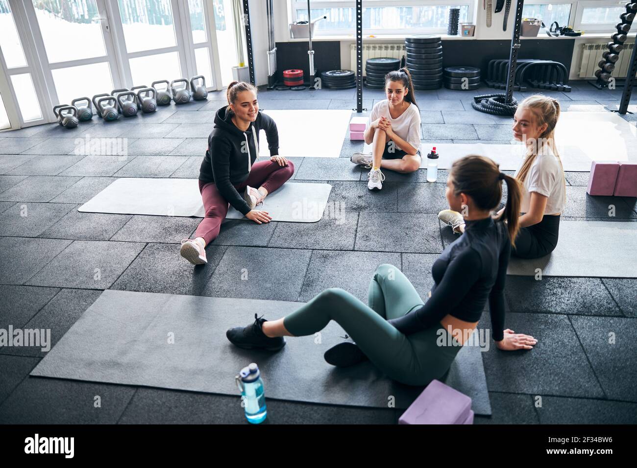 Sportliche junge Damen diskutieren Trainingsplan im Fitnessstudio Stockfoto