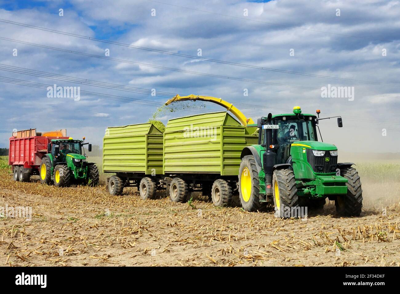 John Deere Traktor Anhänger bei der Arbeit Ernte Mais Deutschland Traktoren landwirtschaftliche Maschinen Stockfoto