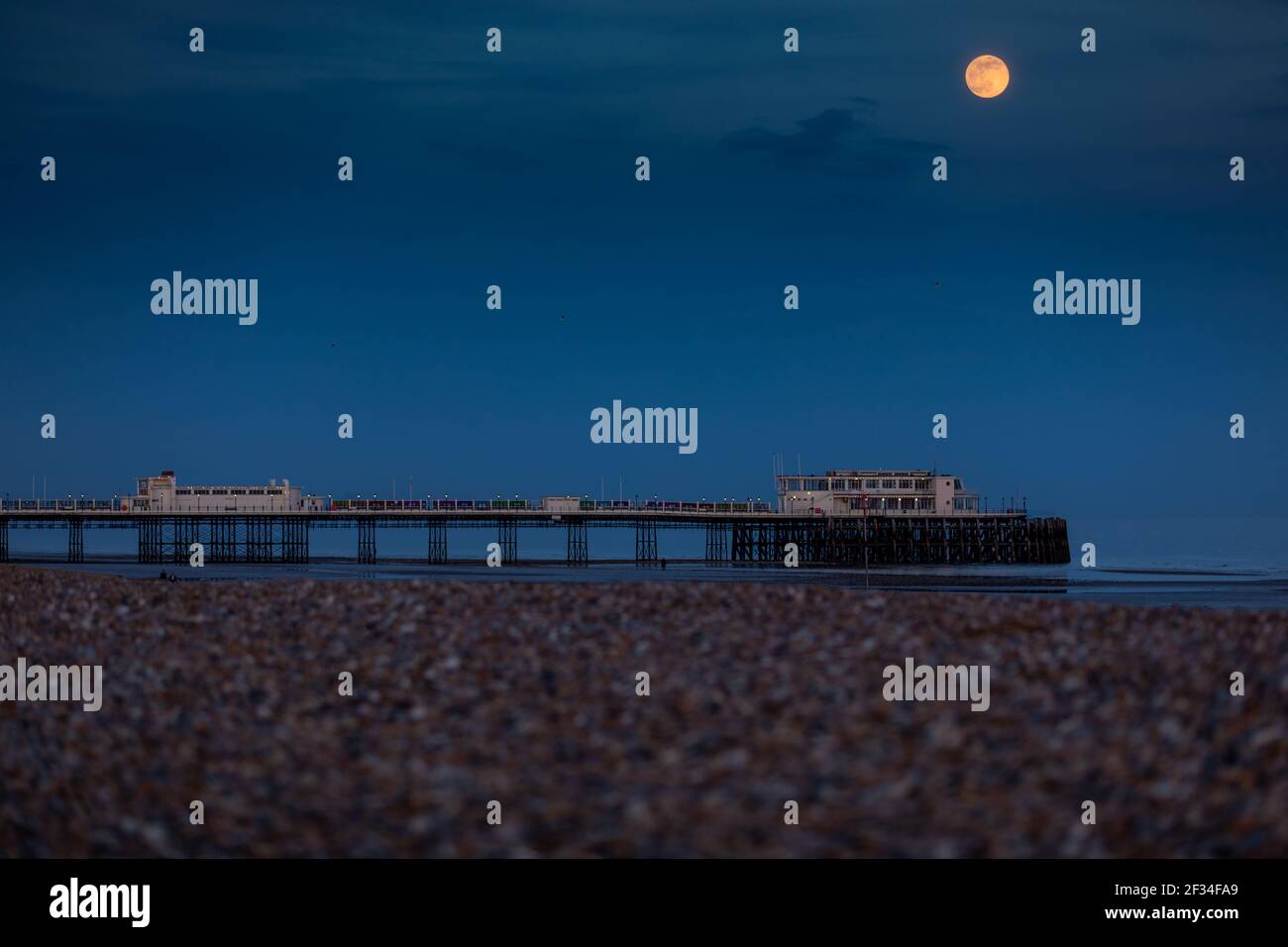 „Super Pink Moon“ steigt heute Abend über Worthing Pier, dem größten Vollmond des Jahres 2020, auf Stockfoto