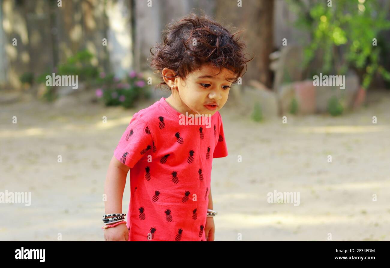 Ein kleiner Junge indischer Herkunft, der mit Erstaunen auf den Boden blickt, indien.Konzept für Kinderfreuden, Kindheitserinnerungen, Gesichtsausdrücke des Babys Stockfoto