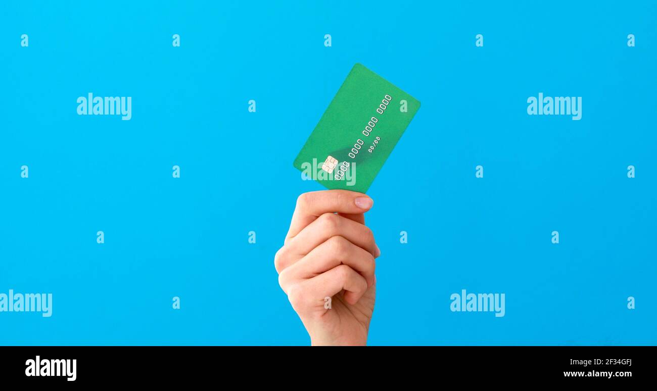Hand hält mockup Kreditkarten und zeigt auf der blauen Hintergrund Stockfoto
