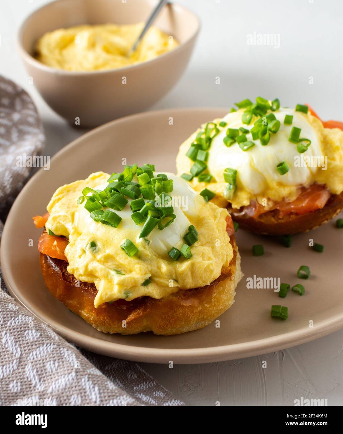Leckeres herzhaftes Frühstück, Eier Atlantic in einem Teller auf weißem Hintergrund, Runde gebratene Brötchen mit Lachs und Eier Benedikt, Sauce Hollandaise Stockfoto
