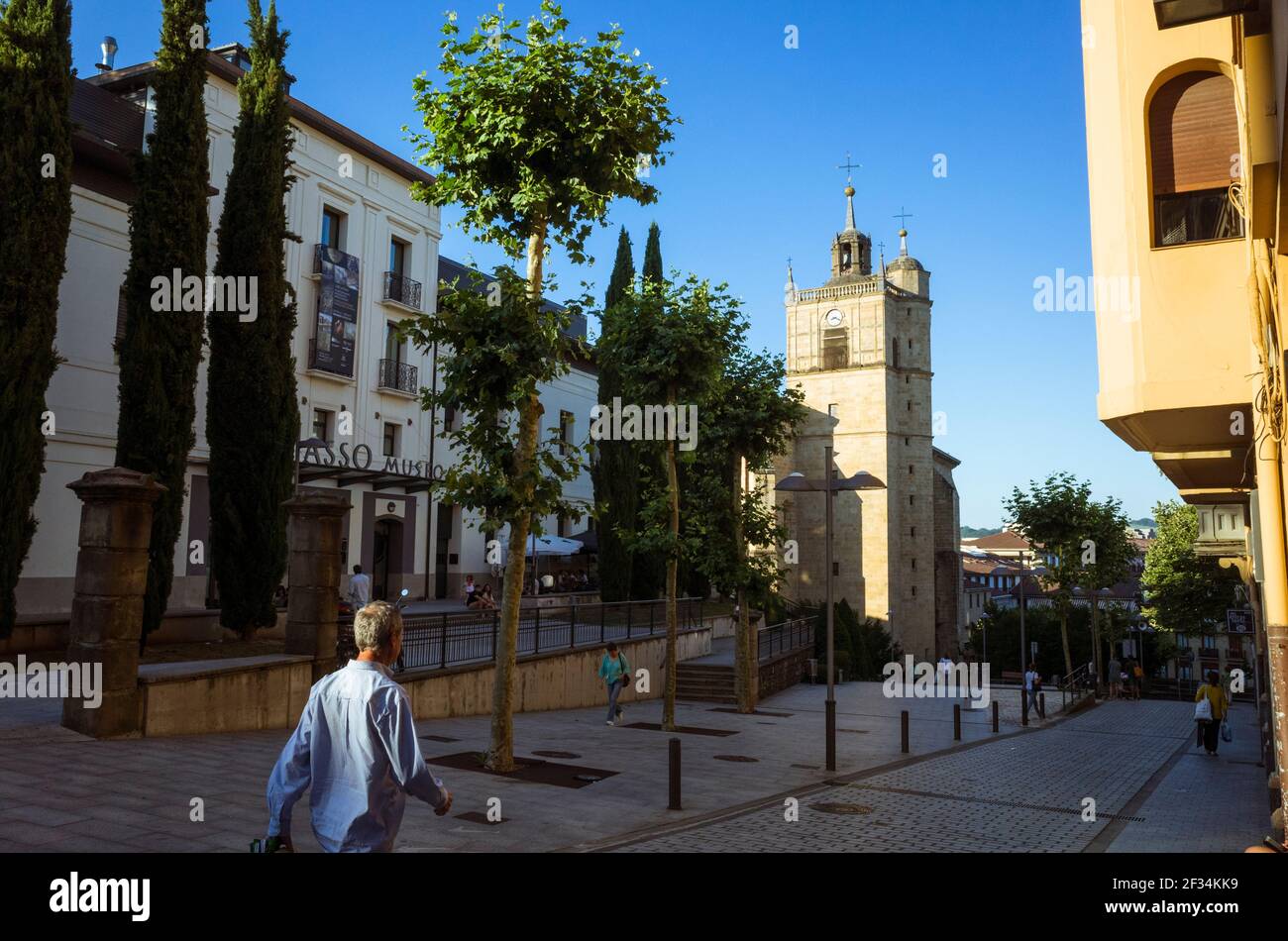 Irun, Gipuzkoa, Baskenland, Spanien - 10th. Juli 2019 : EIN Mann geht am Oiasso Roman Museum vorbei. Glockenturm der Kirche Santa Maria del Juncal in Bac Stockfoto