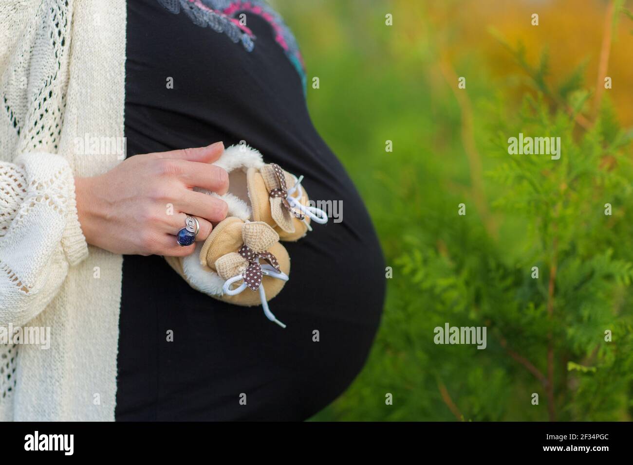 Schwangerer Bauch Nahaufnahme. Junge schwangere Frau, die im Park steht. Mutterschaftskonzept. Platz für Text kopieren. Neues Lebenskonzept. Stockfoto