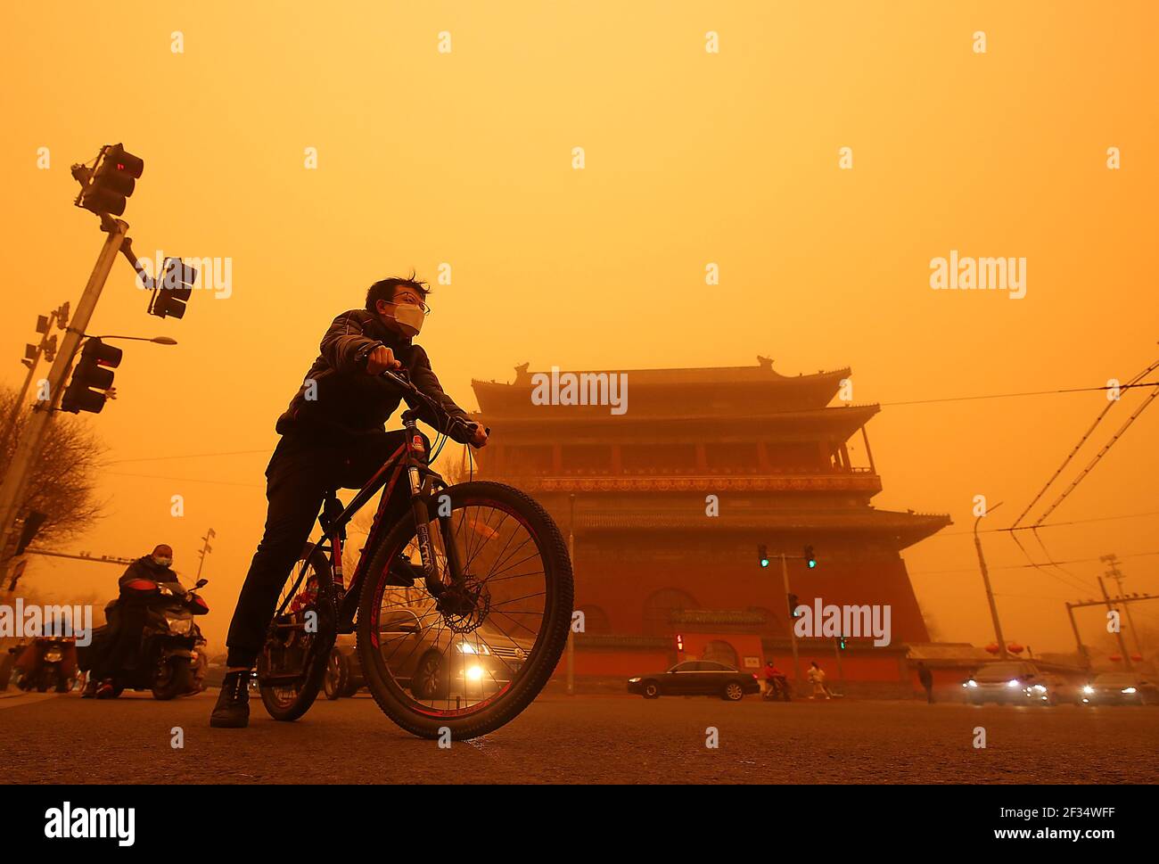 Peking, China. März 2021, 15th. Die Chinesen fahren am Montag, den 15. März 2021, in Peking an einem Tempel vorbei, der von einem dicken Sandsturm umhüllt ist. In einigen Gebieten rund um die Hauptstadt verringerte der starke Sandsturm die Sicht auf weniger als 500 Meter und "ist auch das stärkste Staub- und Sandwetter, das China seit fast 10 Jahren trifft", so die chinesische Meteorologische Regierung. Foto von Stephen Shaver/UPI Kredit: UPI/Alamy Live Nachrichten Stockfoto