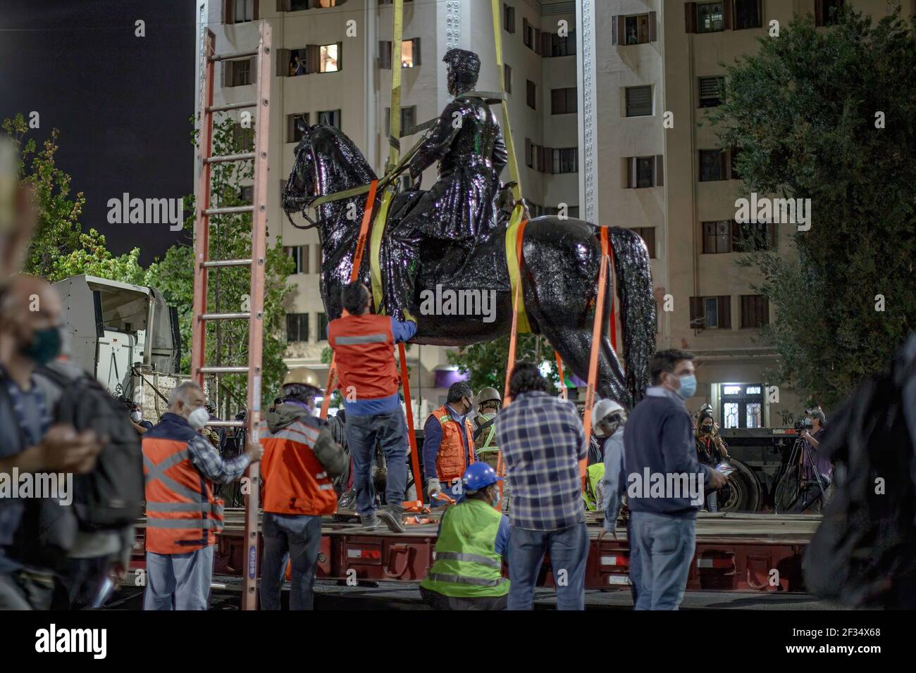 Santiago, Chile. März 2021, 12th. Arbeiter binden die Statue auf einen Anhänger, um sie an einen Restaurierungsort zu bringen. Chiles National Monuments Authority entfernt die Statue von General Manuel Baquedano von der plaza Baquedano, die seinen Namen trägt und das Epizentrum ständiger sozialer Proteste ist. Kredit: SOPA Images Limited/Alamy Live Nachrichten Stockfoto