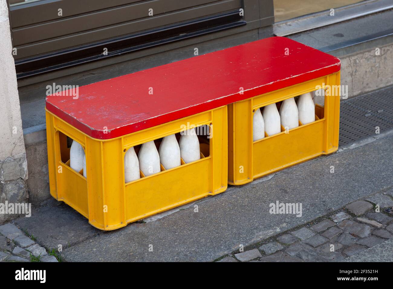 Recycelte Plastikflasche Kiste als Sitzbank in der Straße vor dem Haus Stockfoto