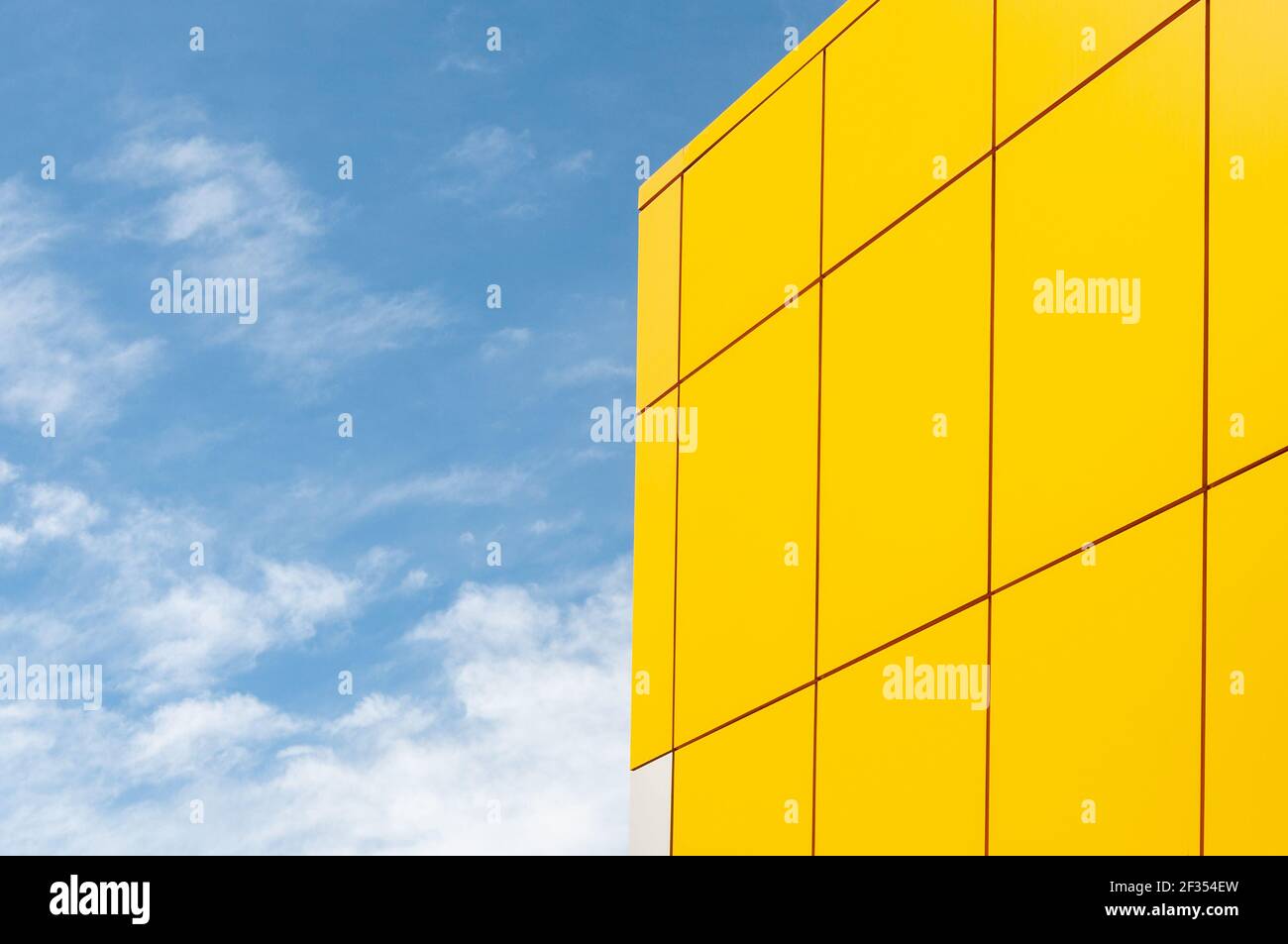 Blauer Himmel, Wolken, die Ecke der Fassade des Gebäudes Stockfoto