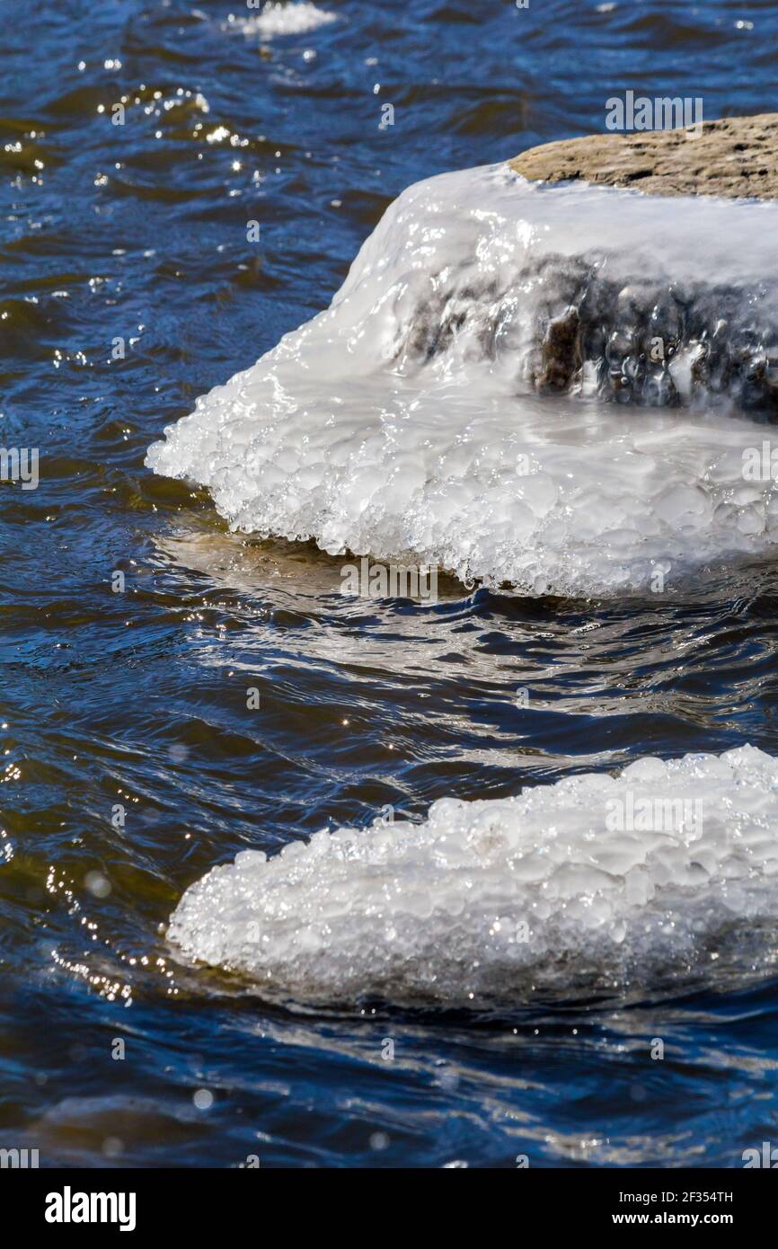 Isoliertes Eis bedeckt Felsen beginnen, auf einem aufzutauen Warmer sonniger Tag am Fox River Stockfoto