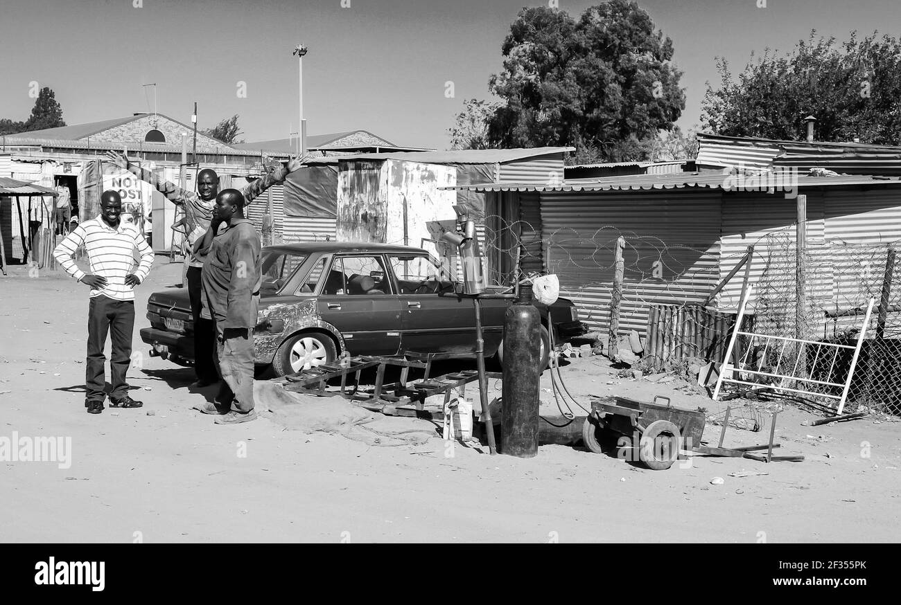 JOHANNESBURG, SÜDAFRIKA - 13. März 2021: Johannesburg, Südafrika, 11. September 2011, Kleiner informeller Straßenhändler, der die Auspuffanlagen von Fahrzeugen auf der Straße repariert Stockfoto